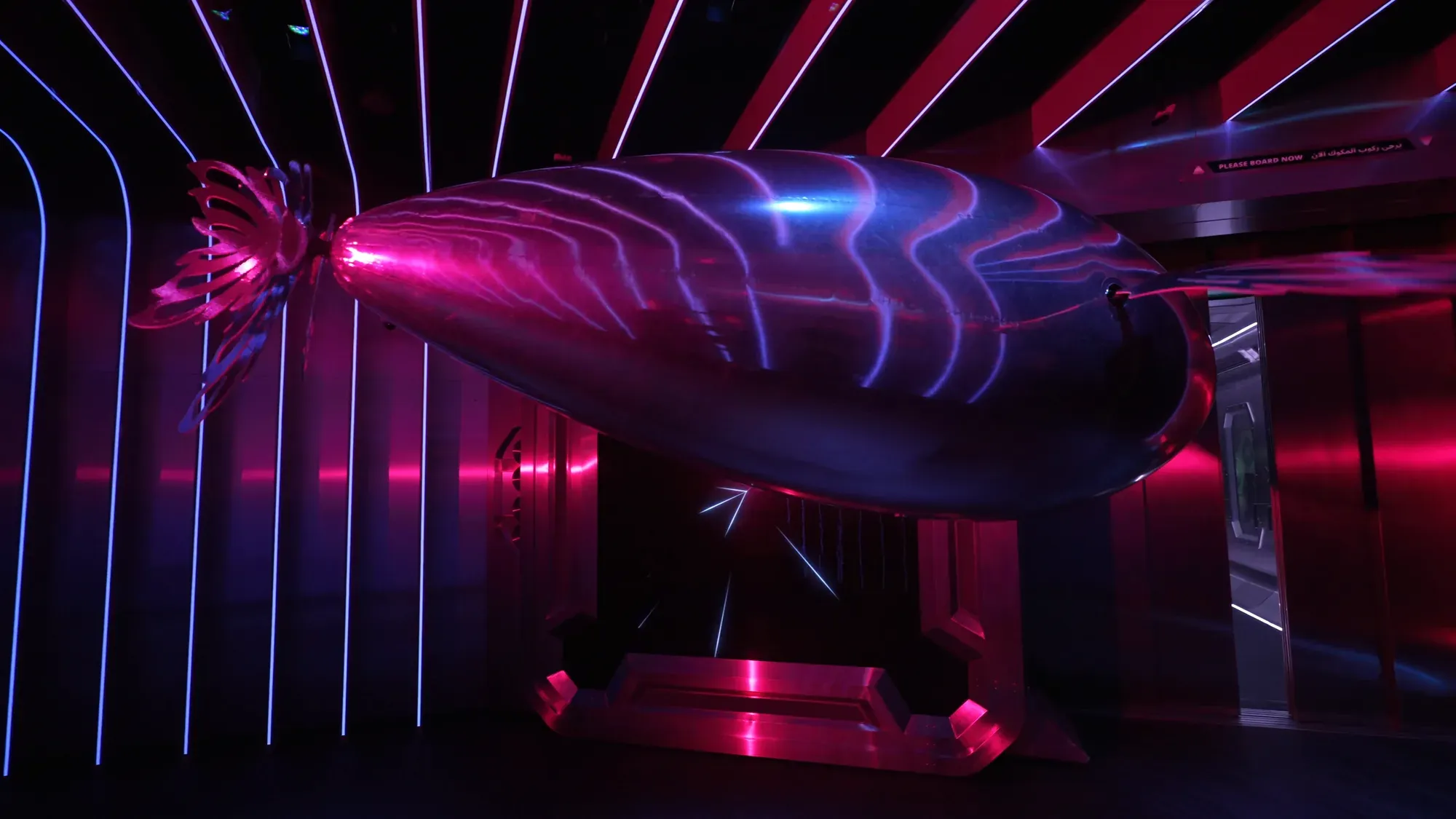 A silver SkyVoyager gliding past rows of neon light strips, the light rippling over its body