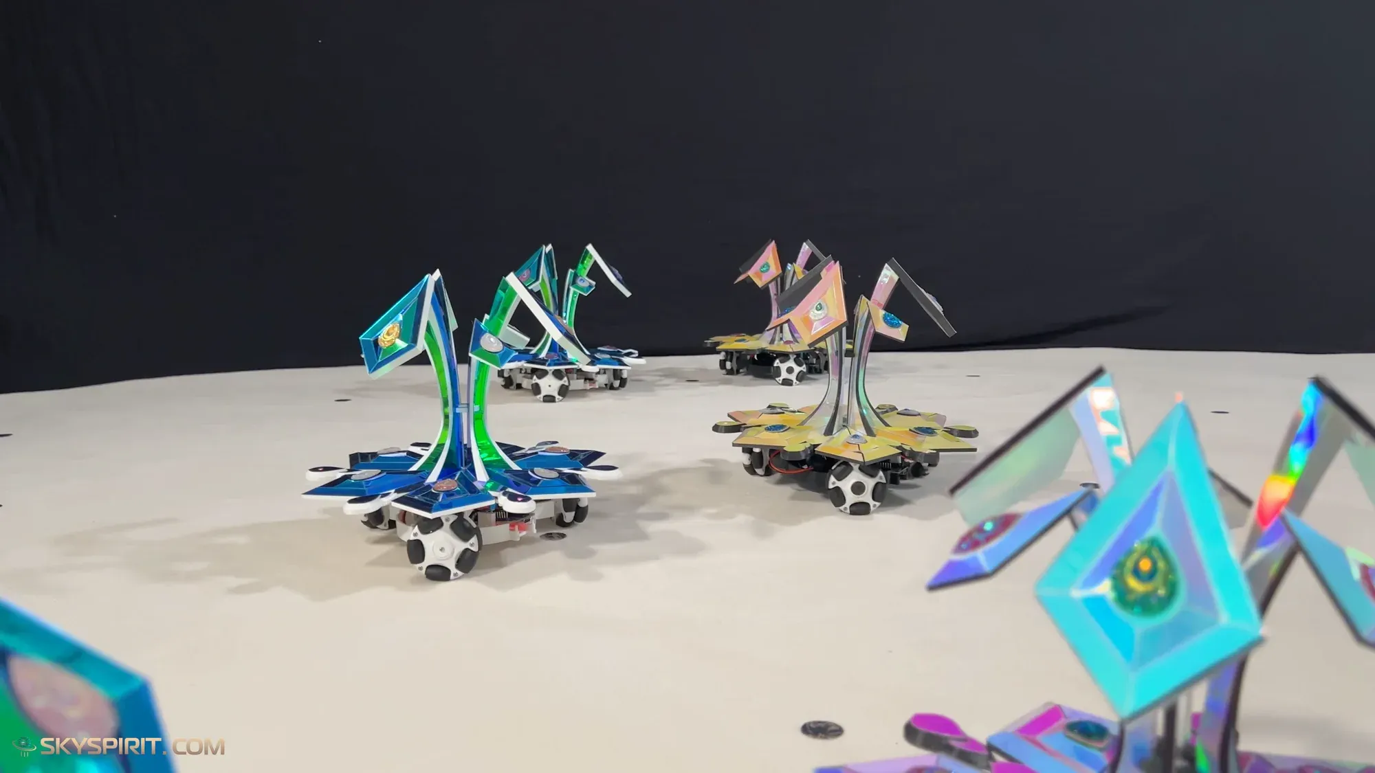 Star-flower robots with tall iridescent petals, seen at floor level